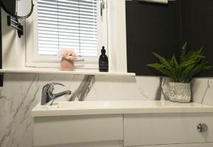 een witte wastafel in een badkamer met een raam bij Sealladh Mairi in Fort William