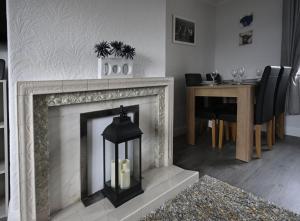 a living room with a fireplace and a dining room table at Sealladh Mairi in Fort William
