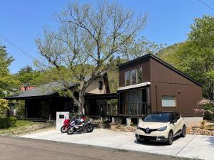 una casa con una moto e una macchina parcheggiata di fronte di Villa Aone - Vacation STAY 82324v a Kawasaki