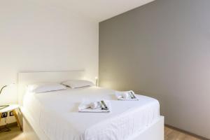 - une chambre avec un lit blanc et des serviettes dans l'établissement Charming flat with view on the Pyrénées - Saint-Jean-de-Luz - Welkeys, à Saint-Jean-de-Luz