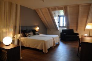 a hotel room with a bed and a chair at Albergue Guiana in Ponferrada +38 photos