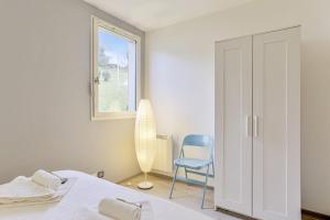 - une chambre avec un lit, une chaise et une fenêtre dans l'établissement Charming flat with view on the Pyrénées - Saint-Jean-de-Luz - Welkeys, à Saint-Jean-de-Luz