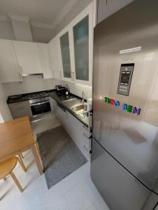 uma cozinha com um frigorífico de aço inoxidável e uma mesa em Casa Veríssimo no Porto