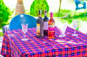 a table with wine bottles and glasses on it at Muhako Hotel in Dar es Salaam