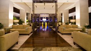 hol hotelu z kanapami i stołami oraz korytarzem w obiekcie SUNSOL UNIK Luxury Hotel w mieście Porlamar