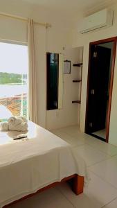 a white bed in a room with a window at Pousada Vilas Boas in Barreirinhas