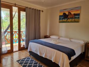 a bedroom with a bed with a horse painting on the wall at Pousada e Restaurante Paraíso Natural in Jijoca de Jericoacoara