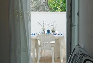 アッリステにあるAppartamenti Blue Houseの白いテーブル(窓際の白い椅子付)