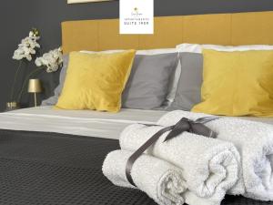 シラクーサにあるCasa Baroneのベッド(白い毛布、黄色い枕付)