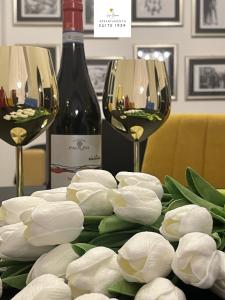 シラクーサにあるCasa Baroneのワイングラス2杯と白い花のテーブル