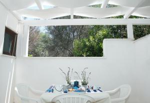 アッリステにあるAppartamenti Blue Houseの白いテーブル(白い椅子付)