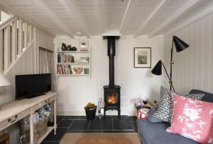 a living room with a couch and a fireplace at Pink Cottage in Penzance