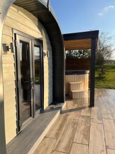 - une entrée voûtée pour une maison avec une terrasse en bois dans l'établissement New Farm Cheshire Holidays, à Winsford