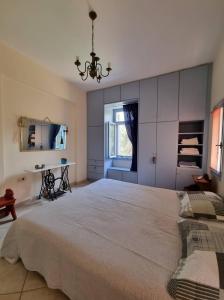 a large bedroom with a large bed and a chandelier at Margouno Eco-Villa, Eggares, Naxos in Eggares