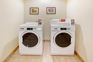 two washing machines sitting next to each other in a room at Scottish Inns and Suites - La Porte in La Porte