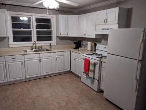 uma cozinha com armários brancos e um frigorífico branco em 1. Lakeview home in Beautiful Guntersville em Guntersville