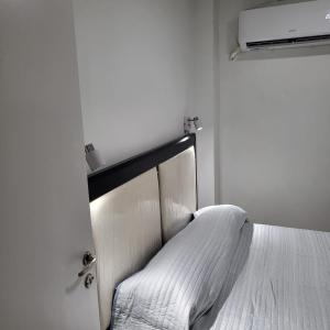 1 dormitorio con 1 cama con colcha blanca en Departamento av.Cordoba en San Juan