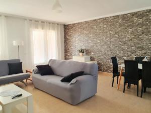 a living room with a couch and a brick wall at Toledo Horizon in Burguillos de Toledo