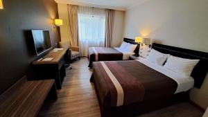 ein Hotelzimmer mit 2 Betten und einem TV in der Unterkunft Hotel Diego de Almagro Osorno in Osorno