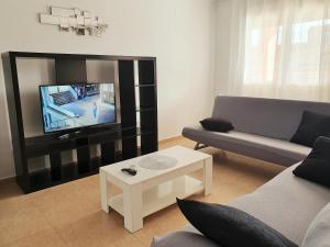 a living room with a couch and a flat screen tv at Toledo Horizon in Burguillos de Toledo