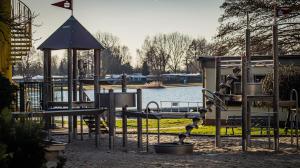 - une aire de jeux dans un parc à côté d'une étendue d'eau dans l'établissement Ferienhaus Frieda Kiebitzsee, à Falkenberg