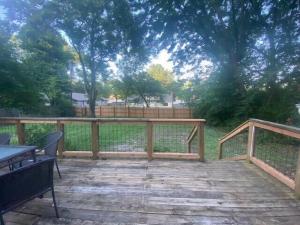 a deck with a fence and a table and benches at Luxurious and peaceful in Topeka