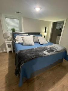 Un dormitorio con una cama azul con almohadas. en Luxurious and peaceful, en Topeka