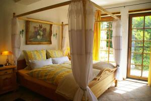 ein Schlafzimmer mit einem Himmelbett und einem Fenster in der Unterkunft Kölliger Hirtenhaus 