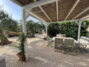 a patio with a table and chairs under a pavilion at CASA ELIO IN VAL DI NOTO in Calabernardo