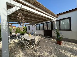 a patio with a table and chairs under a pergola at CASA ELIO IN VAL DI NOTO in Calabernardo