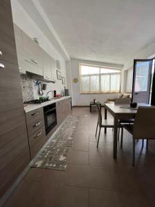 a kitchen with a table and a dining room at CASA ELIO IN VAL DI NOTO in Calabernardo