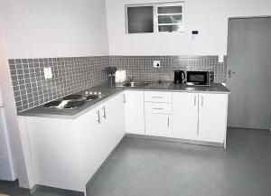 a kitchen with white cabinets and a counter top at Posh Apartment next to Maboneng in Johannesburg