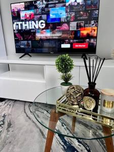 a living room with a glass table and a tv at Posh Apartment next to Maboneng in Johannesburg