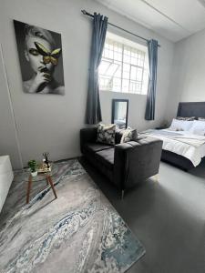 sala de estar con sofá y cama en Posh Apartment next to Maboneng, en Johannesburgo