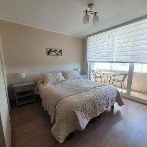 - une chambre avec un lit et une table avec des chaises dans l'établissement Departamento Centro Osorno, à Osorno