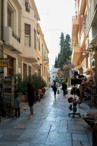 a group of people walking down a street with buildings at Quiet City Center Apt on a Pedestrian Street in Athens