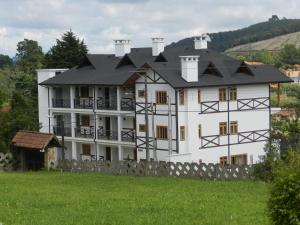a large white house with a black roof at Hotel Villa Greenberg in Monte Verde