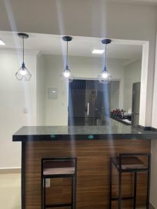 cocina con encimera con 2 sillas y luces en RM hospedagem, en Cabo Frío