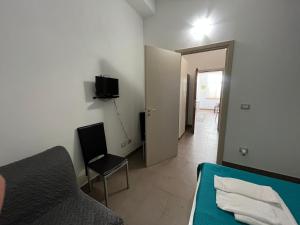 a room with a bed and a chair and a door at CASA ELIO IN VAL DI NOTO in Calabernardo