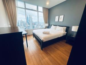 a bedroom with a bed and a large window at Vortex Premium Suites KLCC by SCHIEN in Kuala Lumpur
