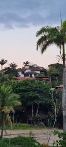a house on top of a hill with palm trees at Casa Panorâmica da Ferradura in Búzios