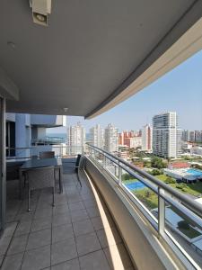 balcón con mesa y vistas a la ciudad en Estelita The Forest Tower 2, en Punta del Este