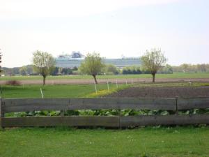 a wooden fence in a field with a garden at boerenskuur De Bedstee groen in Assendelft