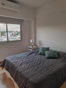 a bedroom with a large bed with two green pillows at Wasi - El Palomar in El Palomar