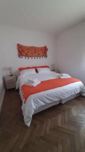 1 dormitorio con 1 cama grande con manta roja en La casa de Delia en Esquel