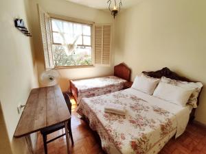 1 dormitorio con cama, mesa y ventana en Pousada Mundo Consciente, en Piauí