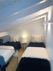 - une chambre avec deux lits et une table avec une lampe dans l'établissement Casas Dos Infantes - Turismo Rural, à Caldas da Rainha
