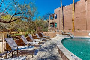 un grupo de sillas sentadas junto a una piscina en Ventana Retreat en Tucson