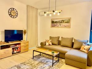 a living room with a couch and a tv at Dekan Forest Apartments Timisoara in Dumbrăviţa