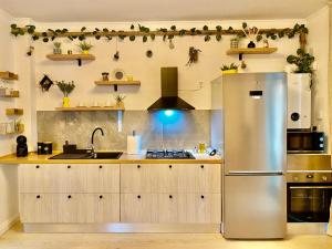 a kitchen with a stainless steel refrigerator at Dekan Forest Apartments Timisoara in Dumbrăviţa